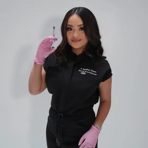 Nurse Practitioner Jenesa Aguiluz-Dizon wearing pink gloves and holding a syringe.
