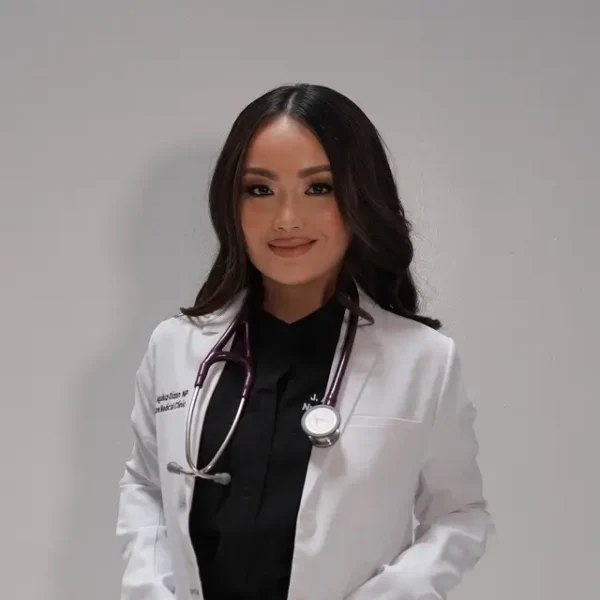 Portrait of Jenesa Aguiluz-Dizon, NP in a white lab coat with a stethoscope.